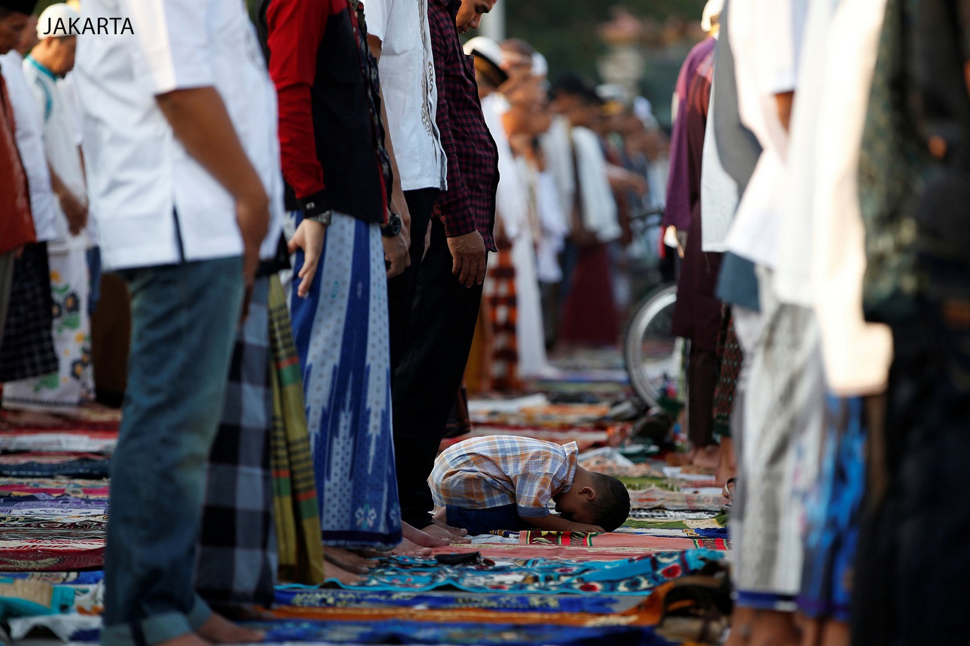 A child attends Eid al-Fitr prayers to mark the end of the holy fasting month of Ramadan at Sunda Kelapa port in Jakarta, Indonesia July 6, 2016. REUTERS/Darren Whiteside