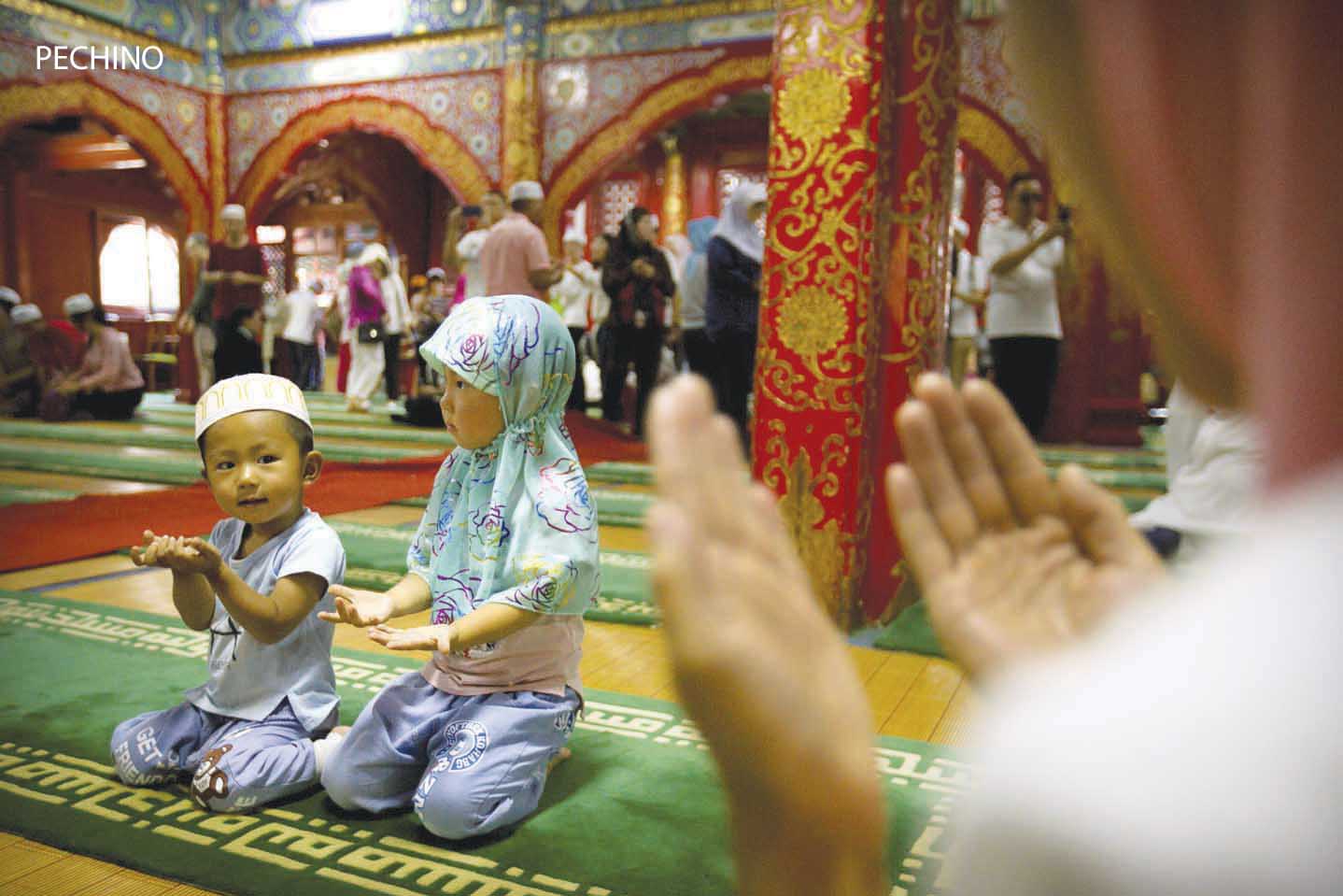 Beijing : Children kneel inside the historic Niujie Mosque after Eid al-Fitr prayer services in Beijing, Monday, June 26, 2017. Although much of the Muslim world celebrated Eid al-Fitr, which marks the end of the holy fasting month of Ramadan, on Sunday, Muslims in China observed the holiday on Monday. AP/PTI(AP6_26_2017_000068B)